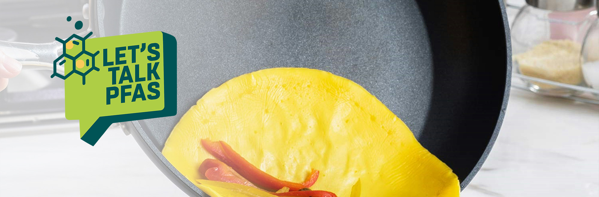 a nonslip pan with an omlette slipping off with a green graphic that says "Let's Talk PFAS". 